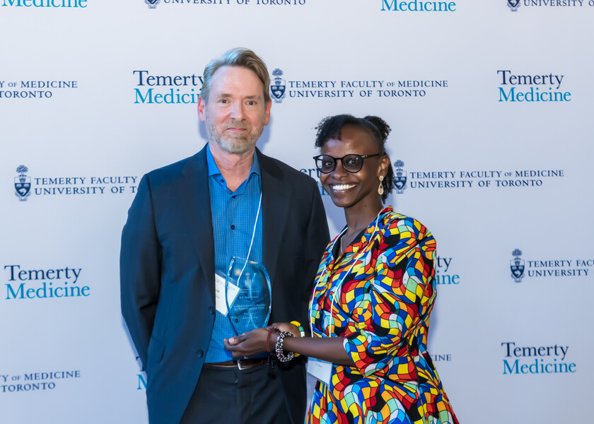 David Hodgson, Vice Chair of Research, presents the R. S. Bush Award for Academic Excellence in Research by a Radiation Oncology Fellow to Juliet Maina.