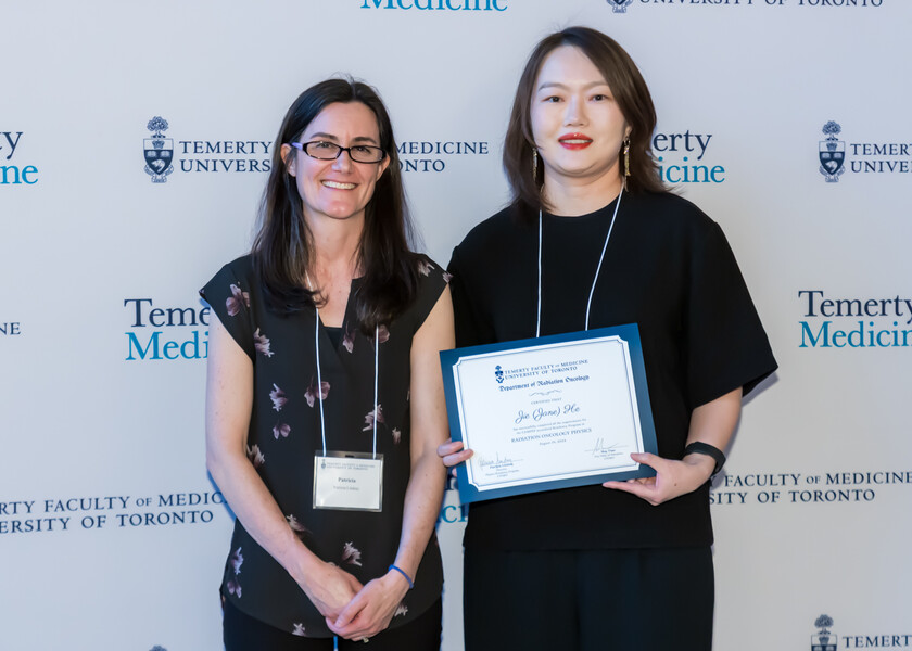 Patricia Lindsay, Director of the Physics Residency Program, presents the graduation certificate to Jane He.