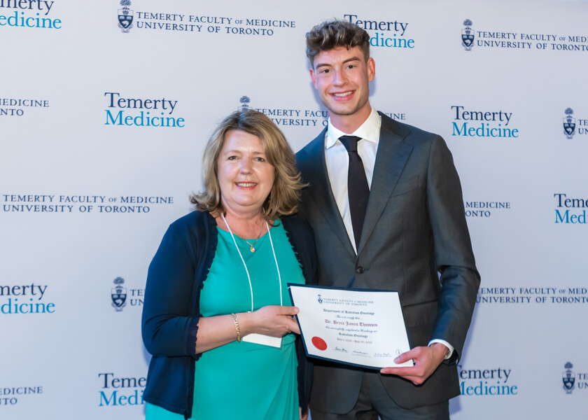 Andrea Bezjak, Director of the Radiation Oncology Residency Program, presents the graduation certificate to Bryce Thomsen.